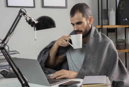 man having coffee while working from home 450x305 - A pandemia e o trabalho remoto. Ao que devemos nos atentar?